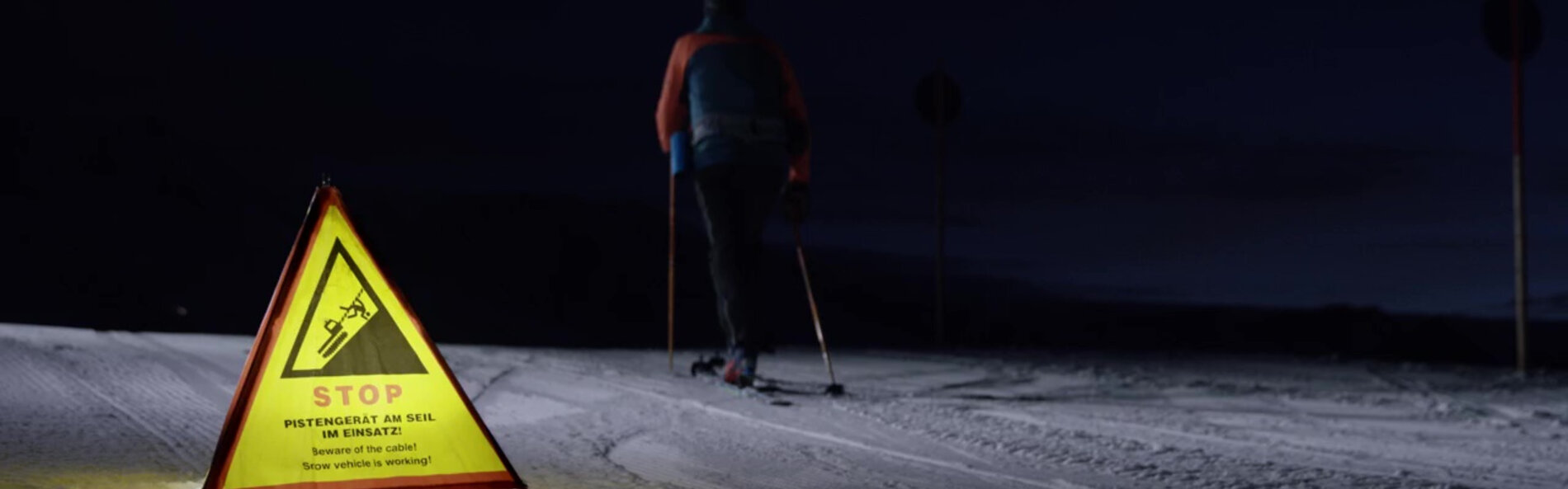 Tourengeher ignoriert Warnhinweis auf Skipiste in der Nacht.